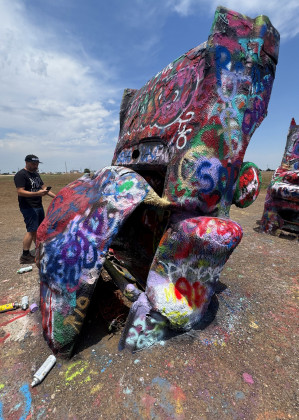 CARS OR CARCASSES? At the Cadillac Ranch today, decades of accretions of spray paint seem to have melted the Caddies’ forms acrylic flowstone, rendering them hardly recognizable as automobiles.