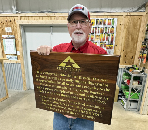 STEVE RILEY, general manager of CCFA, shows off the plaque made by Larry Wood of Idalou that will be mounted on the McAdoo store's wall.