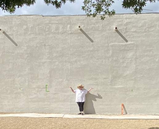The masonry repair and undercoat on the north wall of the Spur Exes building (facing Rickels Park) has been completed—and the surface awaits a new mural by Spur artist Vicki Glass Diggs (center) Any guesses what it might be? | COURTESY PHOTO
