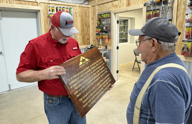 McADOOMAKEOVER Crosby County Fuels general manager Steve Riley (left) shows off a dedication plaque at a grand reopening of the cooperative's ag and tire shop in McAdoo--the lifebood of the small community--which had been destroyed in a 2023 windstorm and rebuilt from the ground up. | THE TEXAS SPUR