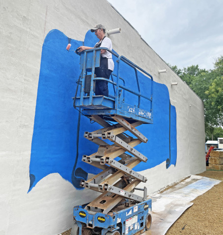 What do YOU think might be planned for this space in Spur’s Rickels Park? ArtistVicki Glass Diggs knows! Follow her progress daily—weather permitting—as she makes use of her talents (and a borrowed lift) to flesh out the design commissioned by the Spur Ex-Students Association, owners of the building abutting the park. | THE TEXAS SPUR