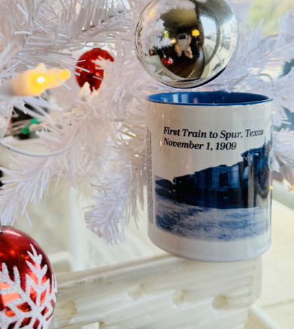SPURCOMMEMORATIVECOFFEEMUG TheTexasSpurnewspaper has revealed the design of its 2025 holiday commemorative mug: “The First Train to Spur, Nov. 1, 1909.” The limited-edition mug is on sale now at the newspaper office or via mail-order, for $15 (sales tax included; shipping additional). | TEXAS SPUR PHOTO