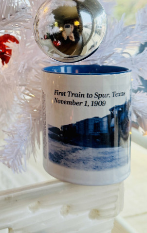 SPUR COMMEMORATIVE COFFEE MUG The Texas Spur newspaper has revealed the design of its 2025 holiday commemorative mug: “The FirstTrain to Spur, Nov. 1, 1909.” The limited-edition mug is on sale now at the newspaper office or via mail-order, for $15 (sales tax included; shipping additional). | TEXAS SPUR PHOTO