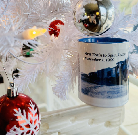 SPUR COMMEMORATIVE COFFEE MUG The Texas Spur newspaper’s2025 holiday commemorative mug honors“The First Train to Spur, Nov. 1, 1909.” Only a few of the limitededition mug are still available at the newspaper office or via mail-order, for $15 (sales tax included; shipping additional). A handful of previous years’ mugs, such as the Vicki Glass Diggs design for The Palace Theater, are also still in stock. | TEXAS SPUR PHOTO