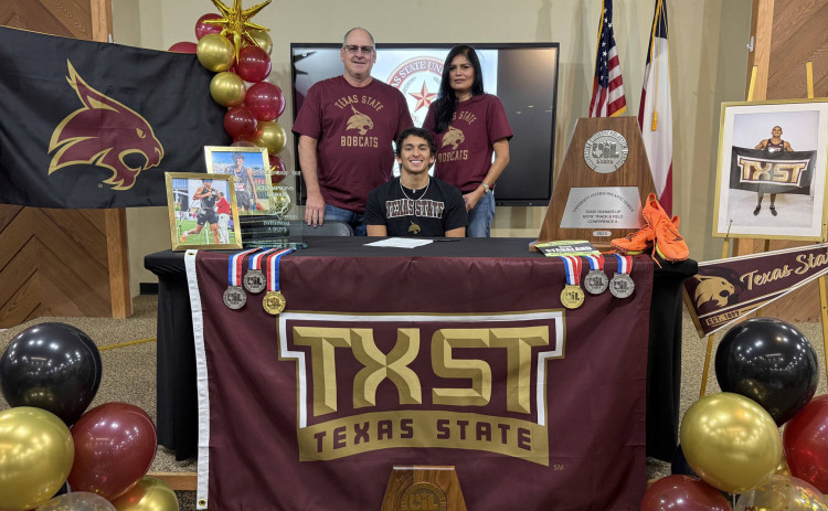 SIGNING DAY Jayton senior Sean Stanaland (center, with parents) who has earned statewide honors in track, football and basketball signed a letter of intent in track last week with Texas State University in San Marcos. The Bobcats currently compete in the NCAA Division I (FBS) as a member of the Sun Belt Conference. The university has announced it will officially join the Pac-12 Conference starting in the 2026-27 athletic season. Stanaland’s signing was celebrated by family and classmates. | COURTESY PHOTO