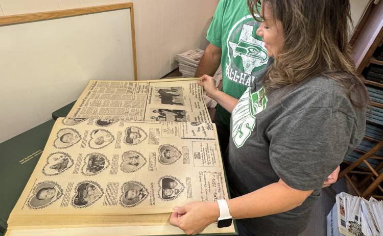PAGES FROM PASTEUP DAYS Dee Leatherman turned the pages of Floyd County Hesperian-Beacon issues from the 1980s, recalling the detailed process of composing newspaper pages when type was produced in long columns to be cut up and pasted onto pages with halftone photographs processed in the darkroom, then transferred onto metal plates for printing. | THE TEXAS SPUR
