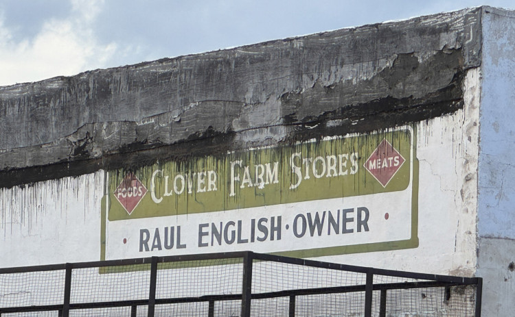 PASTYIELDSTO FUTURE The Clover Farms business sign painted on the unsalvageable stuccoed side of the hundred-year-old structure at 507 Burlington Avenue became a part of Spur’s memory when the building that later housed Wyatt’s Tractor Service was taken down Monday. The building is the second to be razed to make way for new Spur Volunteer Fire Department facilities. | THE TEXAS SPUR